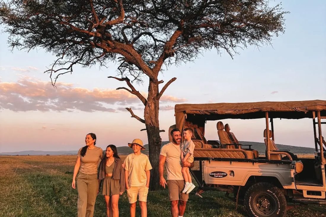 Three generations of a family on safari at sunset