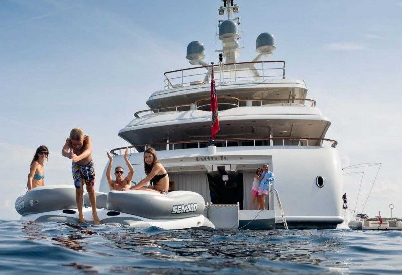 A family swimming off the stern of a private yacht